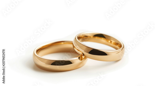 A pair of golden wedding rings isolated on a white background.