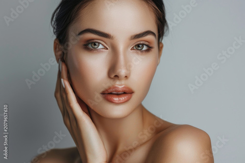 Woman with beautiful face touching healthy facial skin