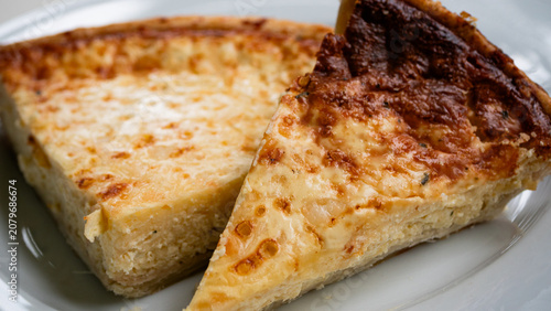 Two slices of the Swedish delicacy Västerbottenpie on a white plate. A cheese pie typically served on holidays and special occasions, containing the key ingredient Västerbotten cheese. This cheese can