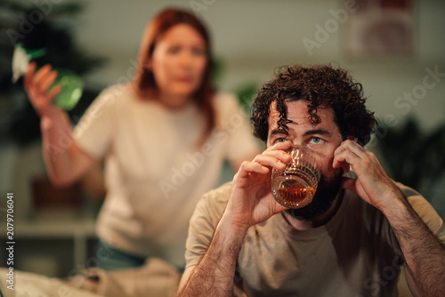 Fotografía Man drinking whiskey, ignoring frustrated woman shouting during domestic dispute