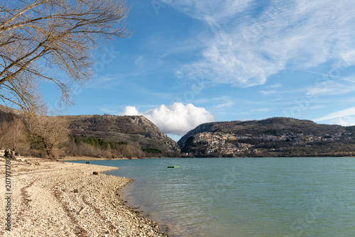 Barrea lake shoreline with mountains and village in Abruzzo Italy
