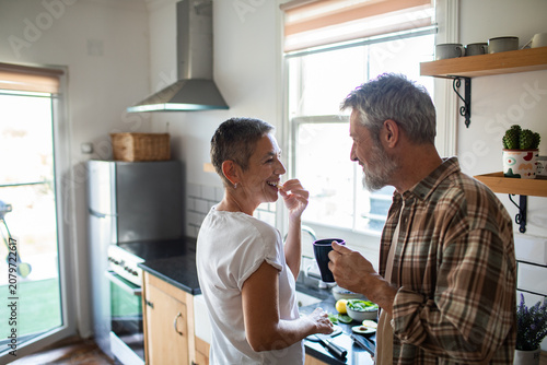 Foto Smiling senior couple cooking together in home kitchen