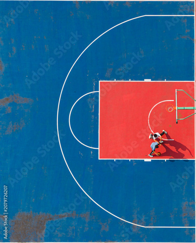 aerial view of two students playing one-on-one basketball on a vibrant red and blue school court. Bright sunlight casts long dramatic shadows, highlighting active outdoor sports and fitness.	