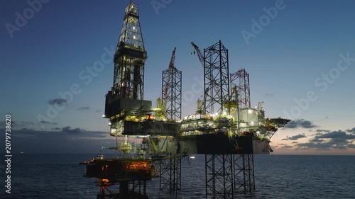 aerial, offshore, jack-up, rig, platform, oil, gas, exploration, production, energy, sunset, twilight, dusk, industrial, maritime, ocean, sea, horizon, sky, orange, derrick, crane, legs, lattice, stee