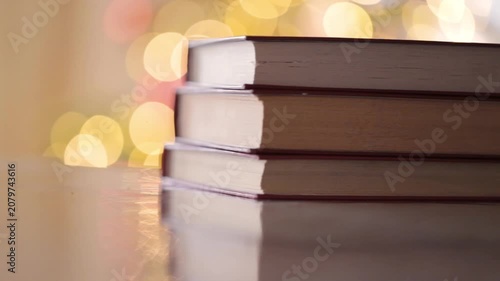 Cozy Bookish Mood.Stack Of Books on a golden bokeh background. Cozy reading. Book blog wallpaper. 4k footage