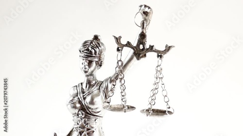 Law and justice concept. A silver statue of Lady Justice with scales on a white background.Legal proceedings, disputes, and criminal cases Symbol. 4k footage
