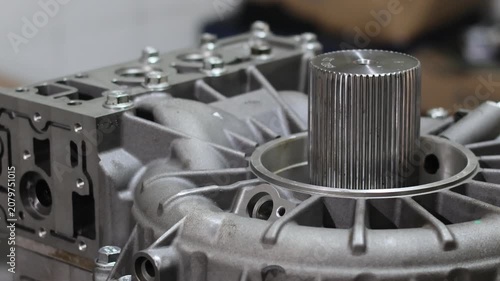 Detailed view of a metallic automatic transmission rear cover assembly showing the central splined output shaft and control valve body channels during overhaul.