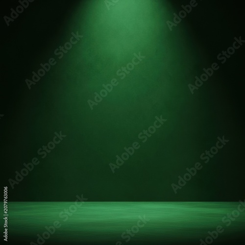 Empty studio room with dark green textured wall and floor illuminated by a single overhead spotlight from the top center, creating a dramatic stage background for product display.
