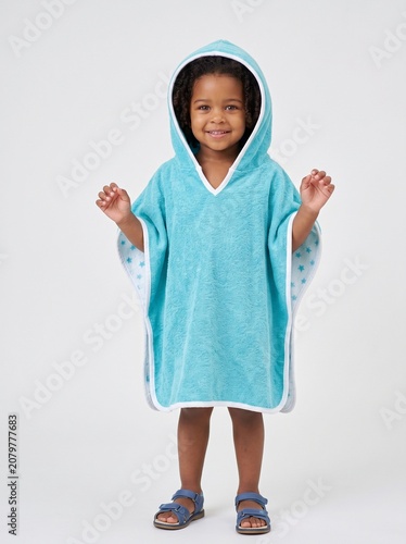 Young girl smiling and playing in a hooded bath towel poncho  