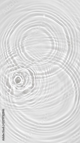 Top view of drop falls into water and diverging circles of water in slow motion