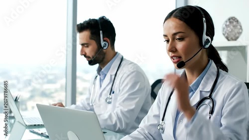 Medical professionals in lab coats and headsets providing online consultation services to patients.