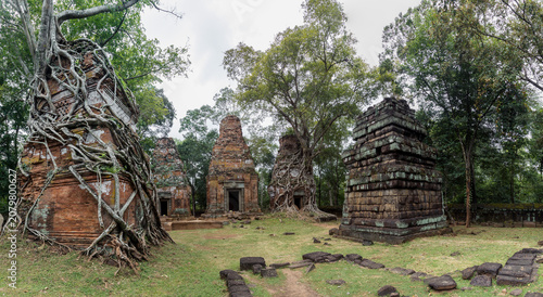 Fotografía Ancient temple ruins in Koh Ker, Cambodia are being reclaimed by nature as massive tree roots engulf the stone structures, creating a surreal and timeless scene