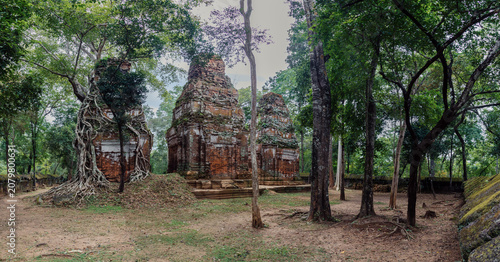 Fotografía Ancient brick temples in Koh Ker, Cambodia, are being reclaimed by nature as massive tree roots engulf the structures, showcasing the power of time and the jungle