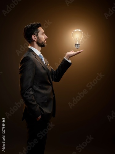 Businessman Holding Light Bulb Representing Innovation, Creative Thinking and Business Idea