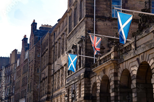 Foto Row of historic stone buildings displaying Scottish Saltire and Union Jack flags