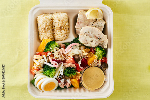 Fotografie Healthy lunch box with chicken and multigrain salad