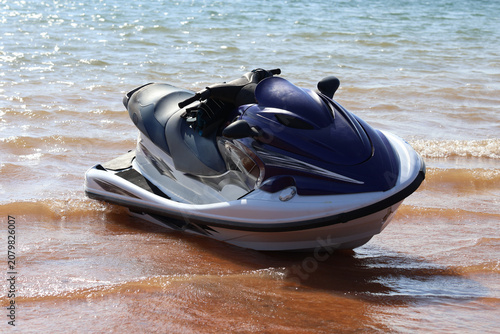 Foto A close-up of a blue-and-white personal watercraft (jet ski) parked near a sandy shore