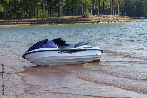 Foto A close-up of a blue-and-white personal watercraft (jet ski) parked near a sandy shore