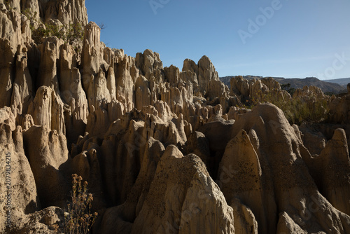 A close-up view of a splintered mountain on a sunny day. There are deep, abrupt gaps within the rock, making them look like massive mountain splinters.