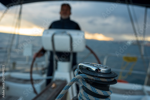 Winch with rope on sailboat deck at sunset