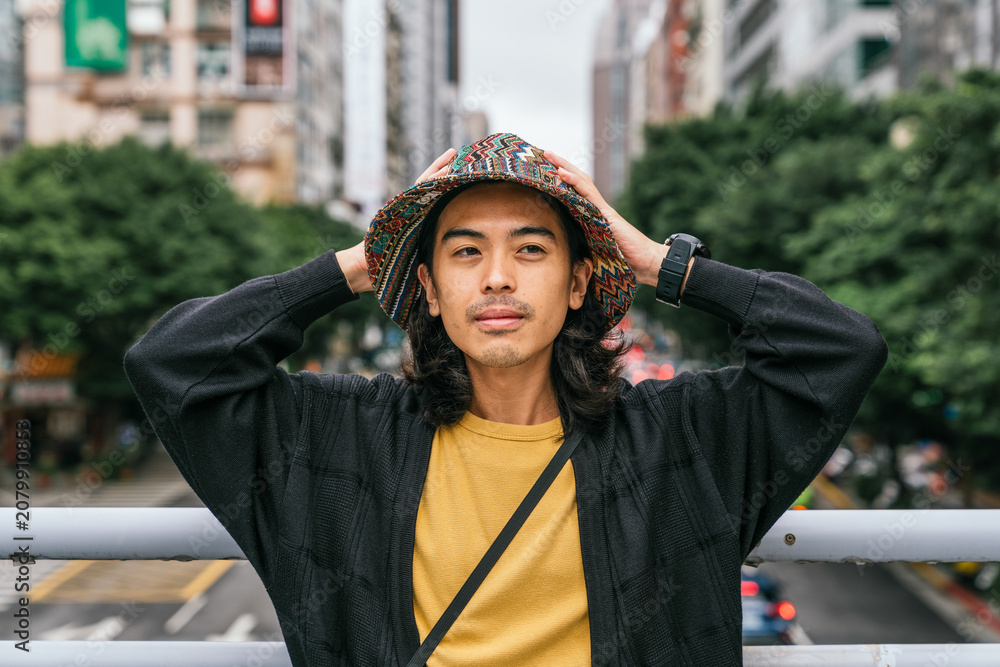 Fototapeta premium Young asian man portrait wearing bucket hat in city