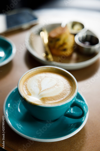 Cup of hot latte coffee on table by the window.