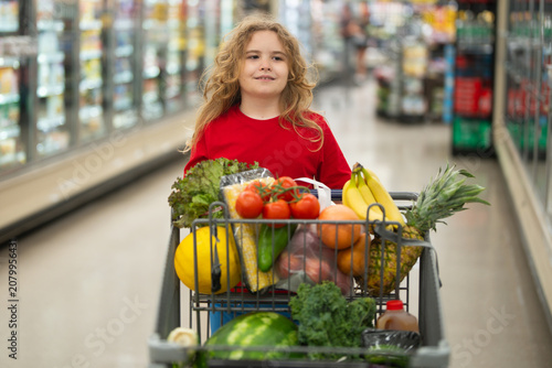 Φωτογραφία Kid shopping with cart in supermarket