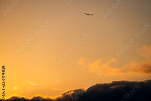 Arlines takes off and gains altitude in the dramatic orange sky