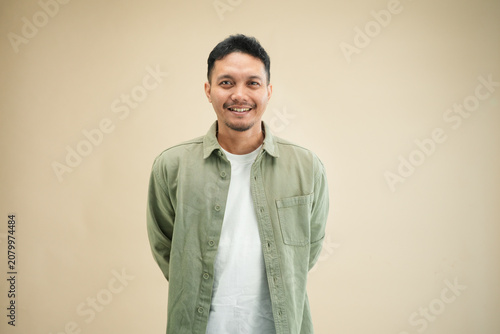 Asian man in green casual shirt with warm smile, friendly and approachable professional expression.