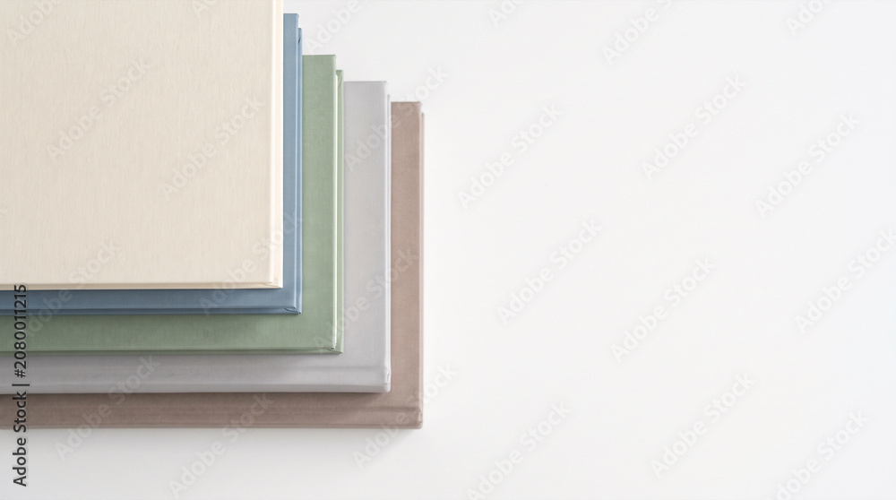 Fototapeta premium Five pastel hardcover books spread on white background with large copy space