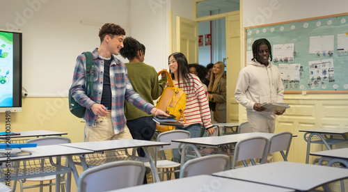 Canvastavla Diverse young adult students walking into a bright classroom to attend a univers