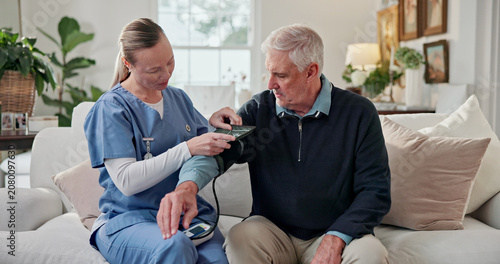 Quadro su tela Doctor, checkup and old man in home with blood pressure machine, healthcare or hypertension exam
