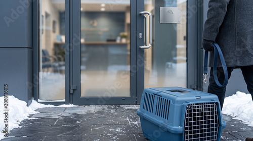 Person with pet carrier outside office entrance