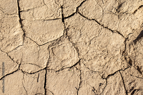 Fotografie Dry and cracked soil texture caused by global warming and severe drought conditions