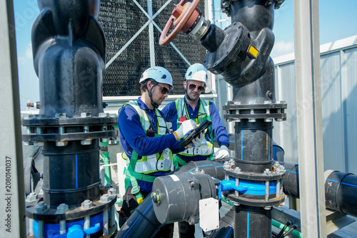 HVAC Engineers Inspecting Rooftop Cooling Tower. Industrial Maintenance Operation.