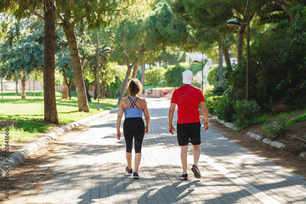 Fototapeta premium Senior couple enjoying an outdoor fitness walk together in a green park