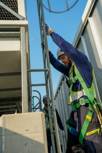 HVAC Engineer Ascending Cooling Tower Ladder. Rooftop Maintenance Work. Professional Industrial Inspection.