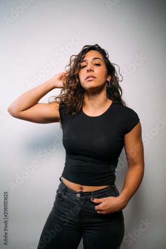 Confident young woman posing with hand in hair