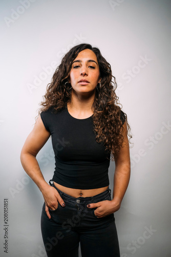 Young adult woman standing with hands in pockets