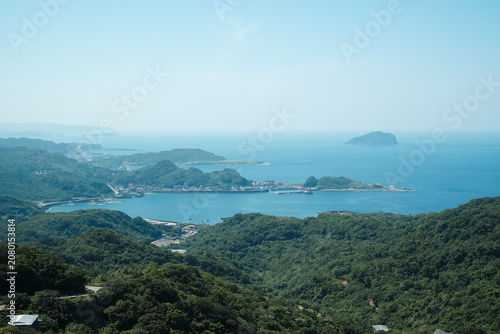 Scenic view of Jiufen with lush green hills and traditional buildings overlooking the ocean at Taiwan.