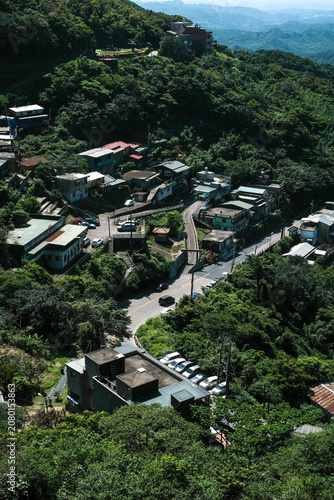 Scenic view of Jiufen with lush green hills and traditional buildings overlooking the ocean at Taiwan.