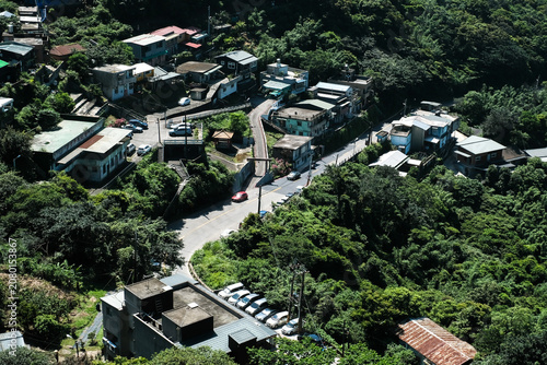 Scenic view of Jiufen with lush green hills and traditional buildings overlooking the ocean at Taiwan.