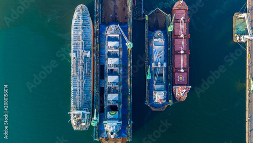 Φωτογραφία commercial cargo ships and heavy oil tankers undergoing essential maintenance and structural repairs inside floating dry docks at a busy industrial shipyard marine facility