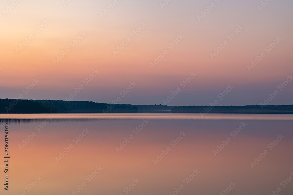 Fototapeta premium Serene pastel sunset reflection on a perfectly calm lake in Finland