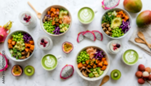 Top-down view of a minimalist marble counter filled with vibrant vegan bowls, puddings, and fresh fruits with a soft artistic blur for premium health food backdrops.
