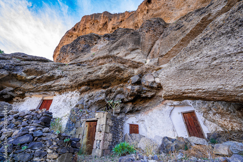 Fotografie Ancient cave houses carved into volcanic rock cliffs in the mountainous interior of Gran Canaria, Canary Islands, Spain