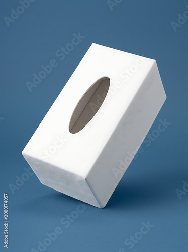 Isolated white rectangular tissue box cover with a textured surface on a solid blue background for home interior decor
