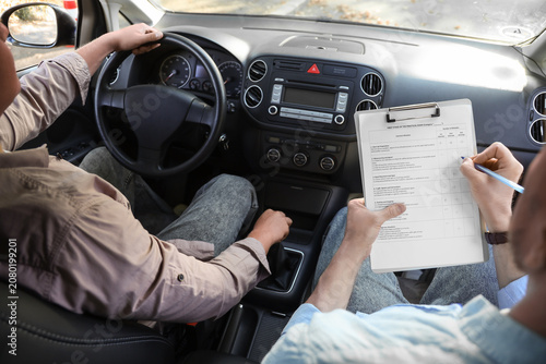 Bild auf Leinwand Male examiner with instructor passing driving license test in car
