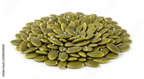 Pile of raw organic pumpkin seeds with sea salt grains