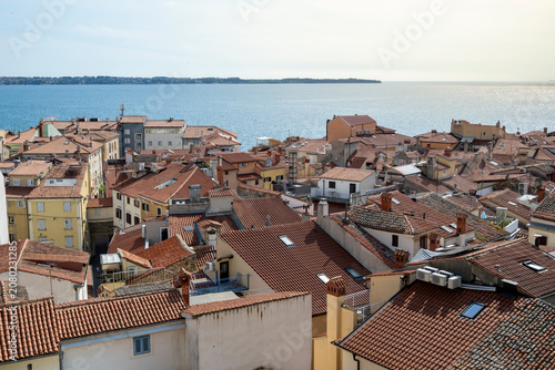 Obraz na plátně Historic rooftops and lush greenery overlooking the Adriatic Sea in Piran Sloven